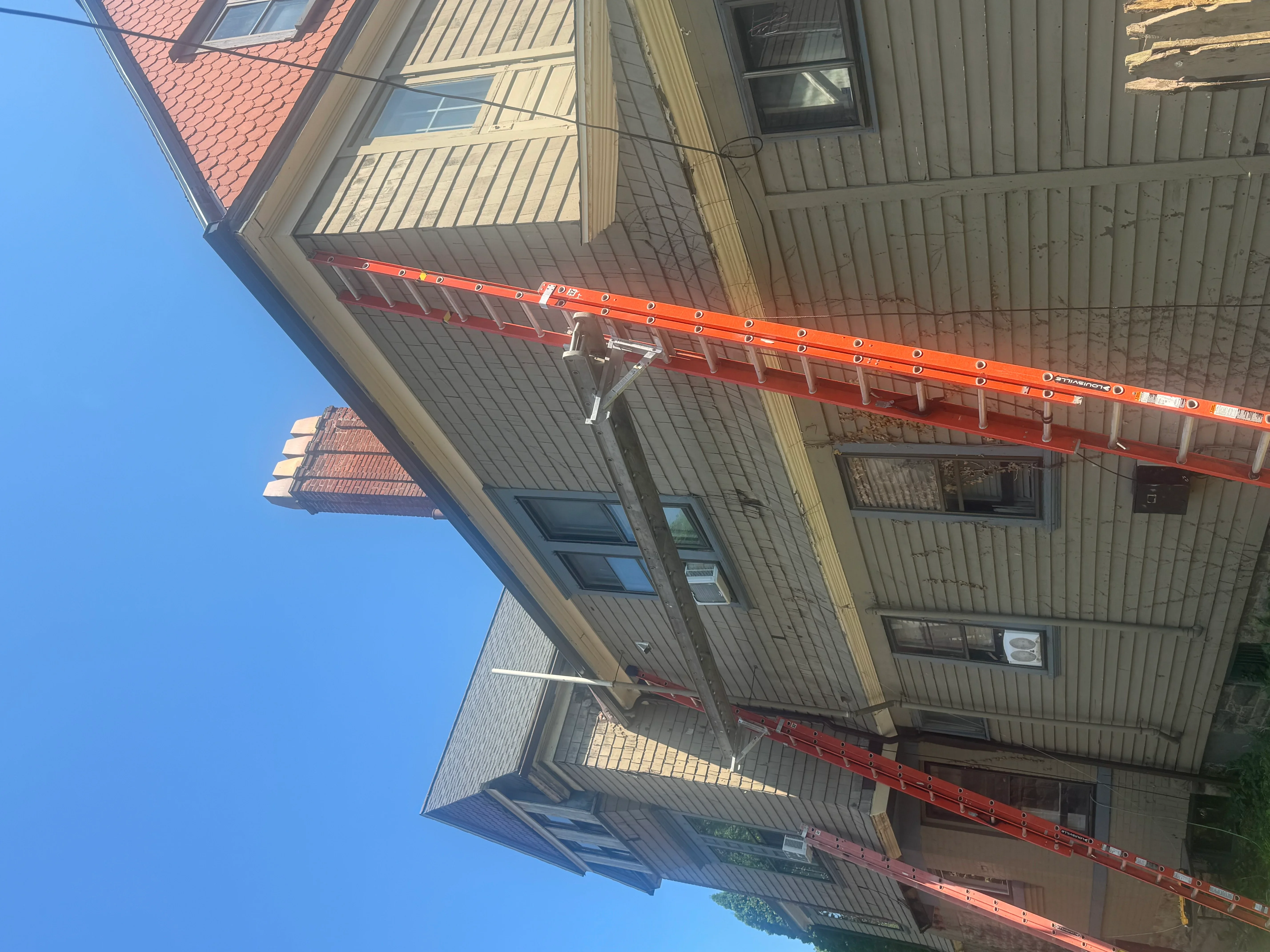 Standing seam metal roof with new gutters and downspouts on residential home