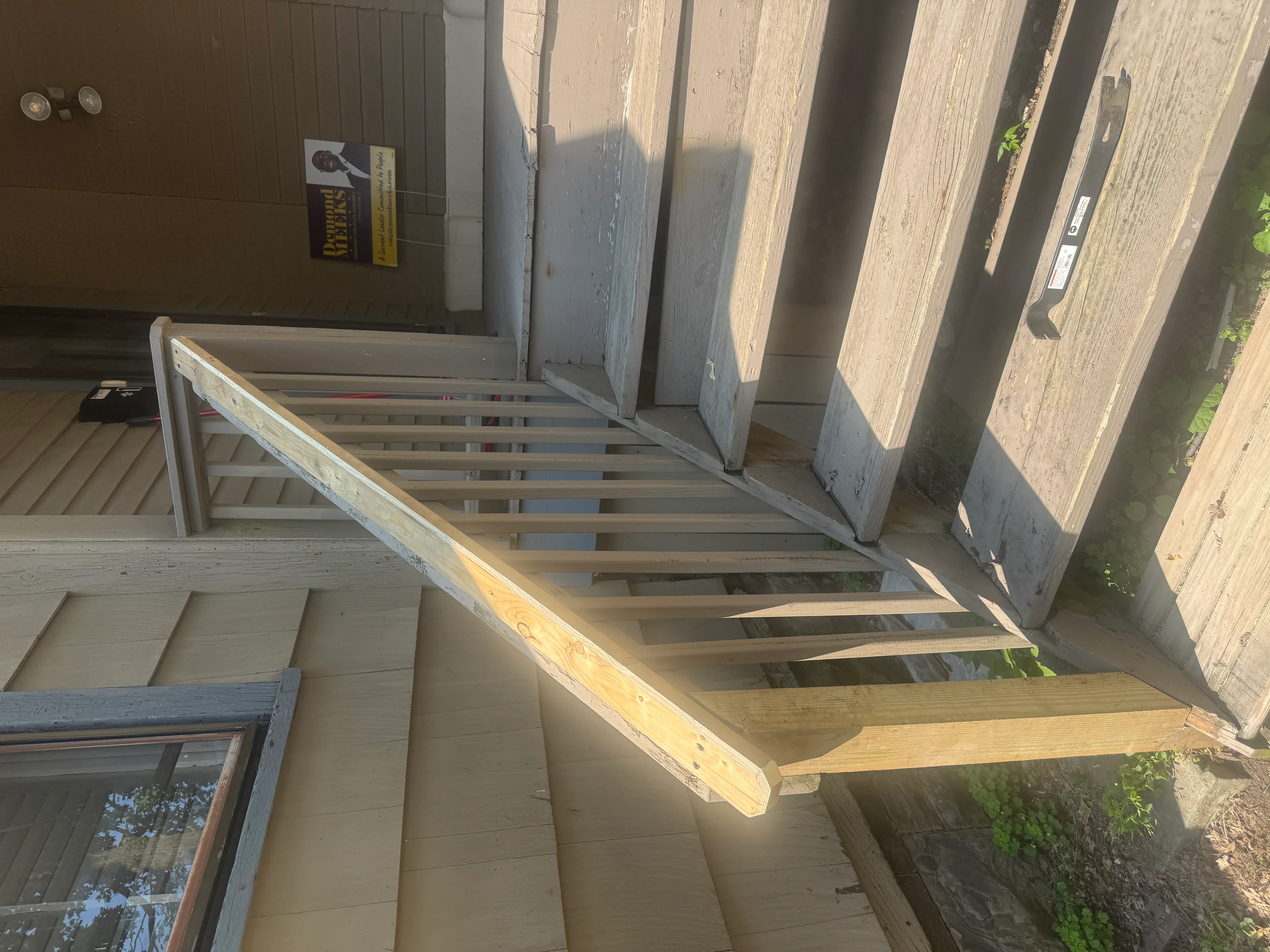 Pressure-treated lumber deck frame with joists and beams on concrete pad