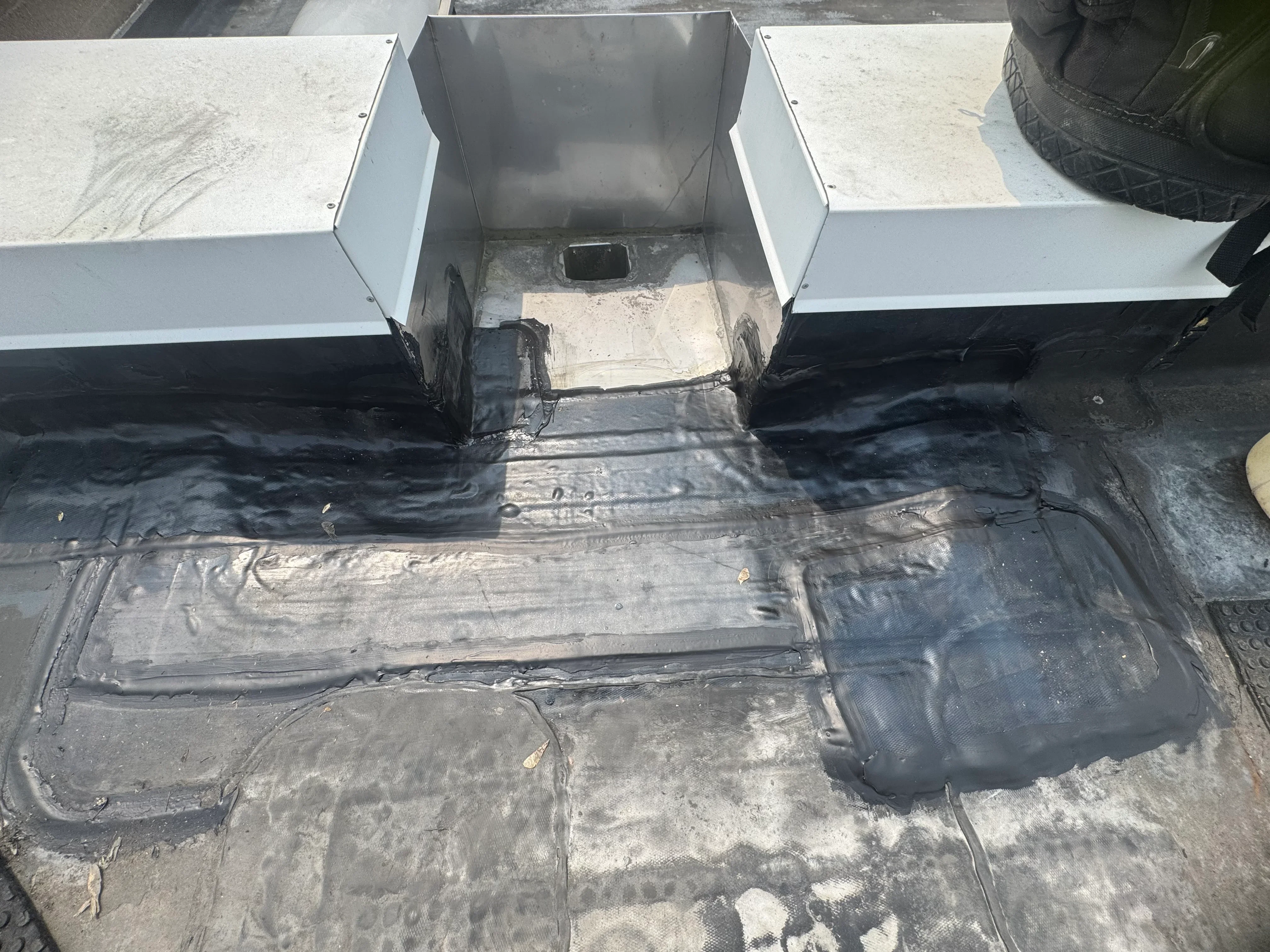 Black EPDM membrane with white metal flashing and coping on flat roof installation